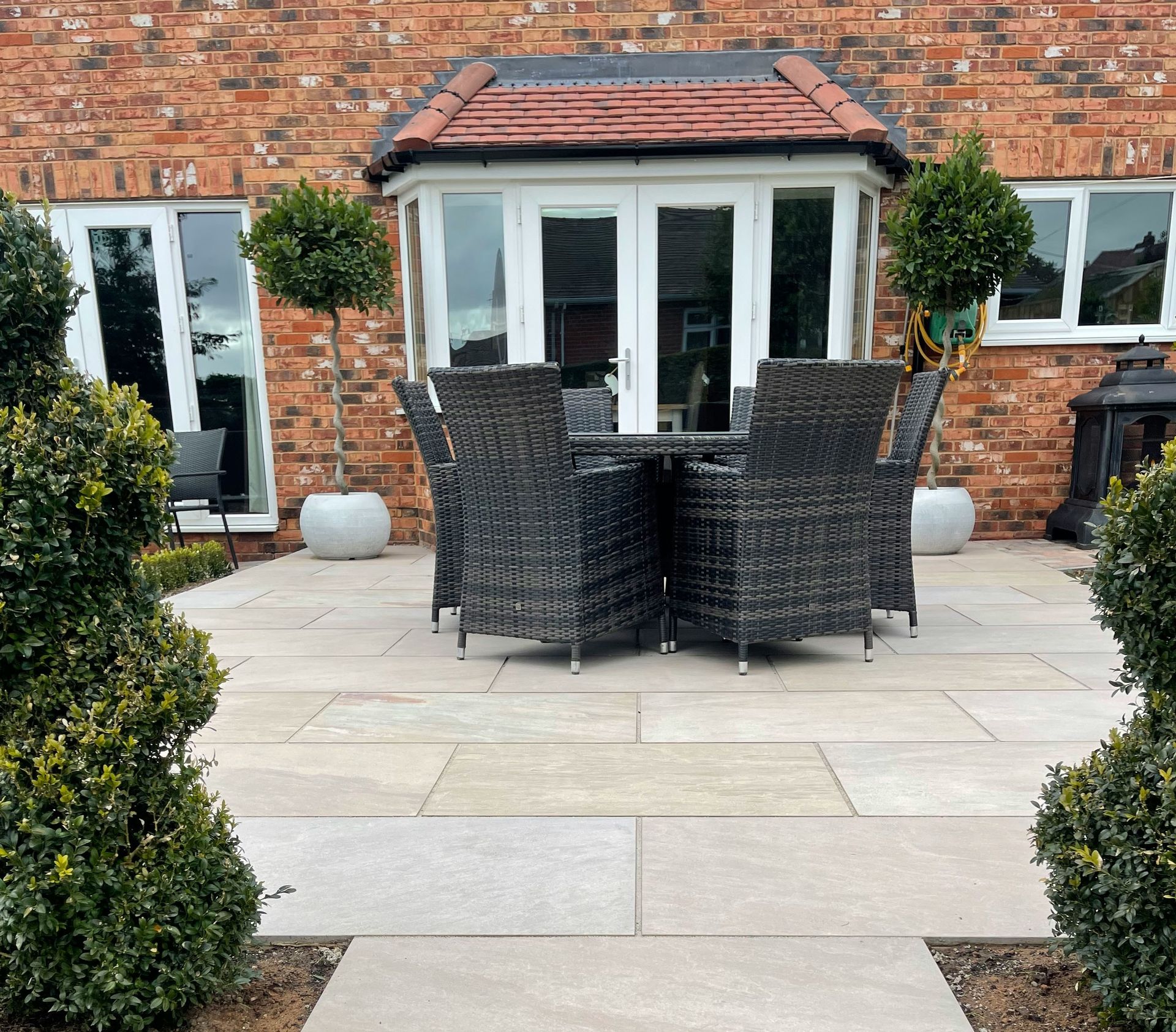 a patio with a table and chairs in front of a brick building